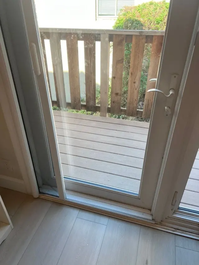 Patio door opening onto a wooden deck, fitted with a door screen